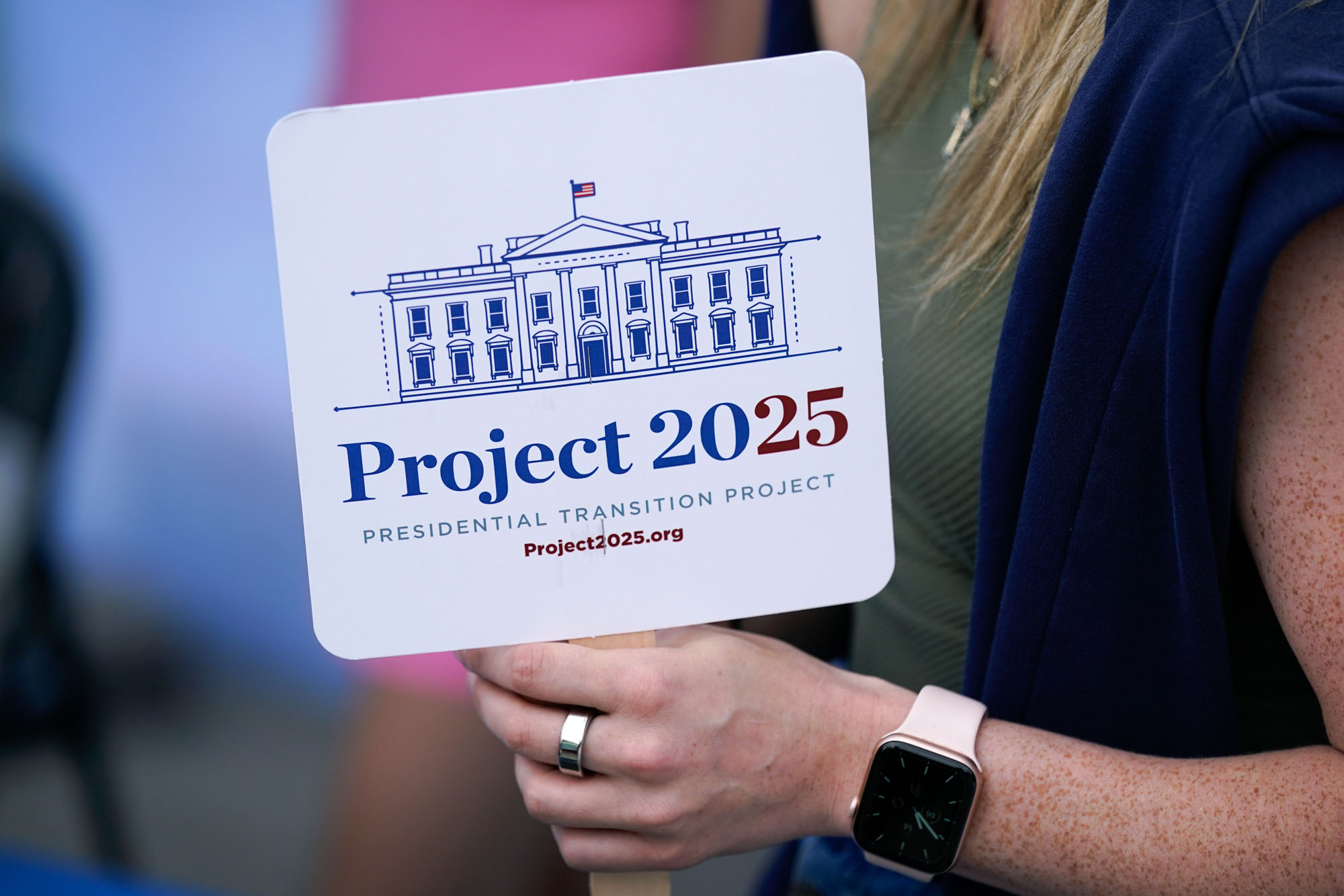 Kristen Eichamer holds a Project 2025 fan. Kristen Eichamer holds a Project 2025 fan.