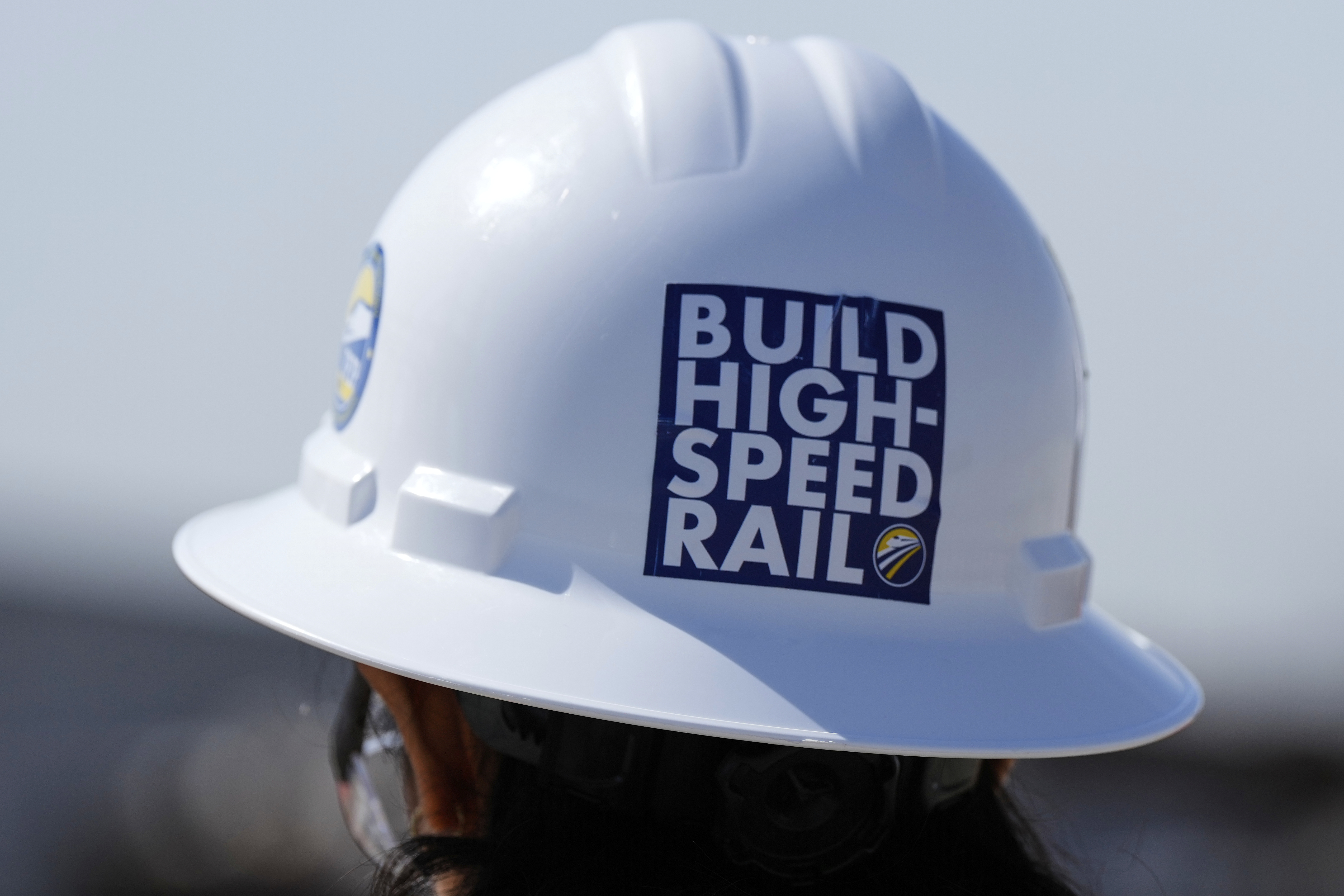A construction hat on a worker says Build High-Speed Rail. A construction hat on a worker says Build High-Speed Rail.
