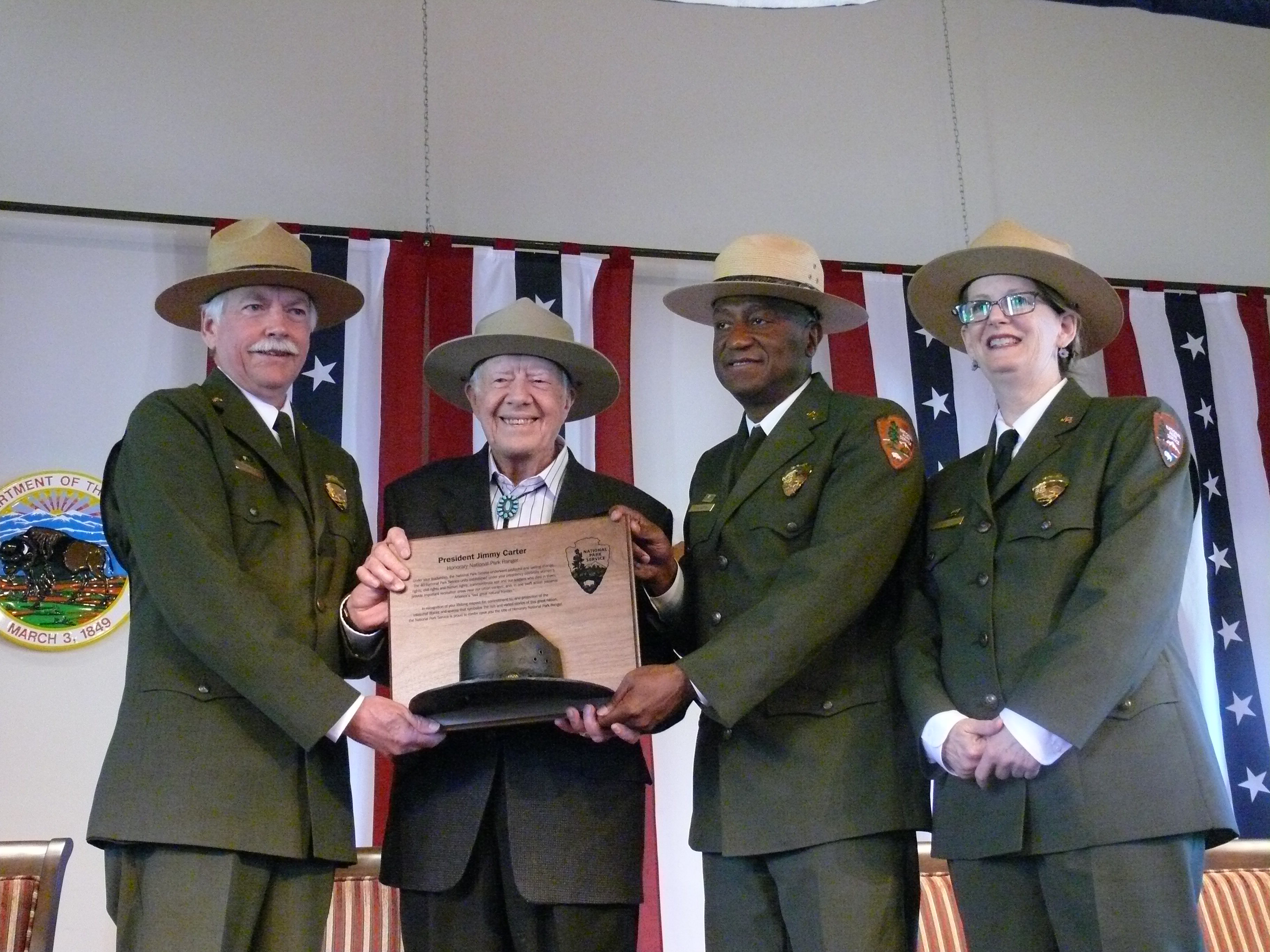 From left to right, then-NPS Director Jonathan Jarvis, Former President Jimmy Carter, NPS Southeast Region Director Stan Austin and Jimmy Carter National Historic Site Superintendent Barbara Judy in April 2016. Carter is holding a plaque From left to right, then-NPS Director Jonathan Jarvis, Former President Jimmy Carter, NPS Southeast Region Director Stan Austin and Jimmy Carter National Historic Site Superintendent Barbara Judy in April 2016. Carter is holding a plaque